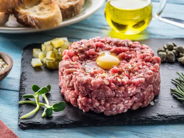 Steak tartare çiğ Bıldırcın yumurta sarısı, Kapari ve ekmek ile servis. Et yemek.