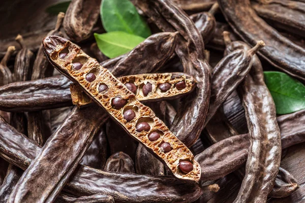 Carob Pods Och Carob Bönor Tabellen Trä — Stockfoto