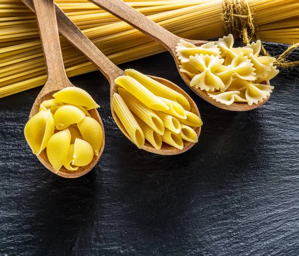 Verschiedene Nudelsorten Holzlöffeln Auf Dem Tisch Ansicht Von Oben — Stockfoto