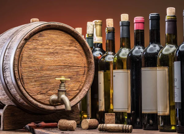 葡萄酒瓶排和橡木酒桶 — 图库照片