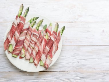 Yeşil kuşkonmaz lahanası ahşap masa jambon sarılı. Üstten görünüm.