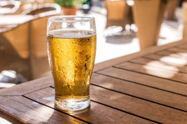 Ahşap masa üzerinde light bira bardak.