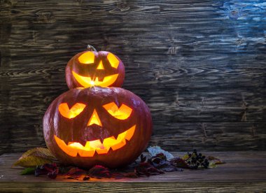 Sırıtan kabak latern veya jack-o'-lantern Cadılar Bayramı sembollerin biridir. Cadılar Bayramı özniteliği. Ahşap arka plan.