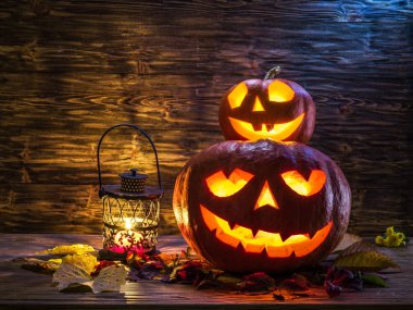 Sırıtan kabak latern veya jack-o'-lantern Cadılar Bayramı sembollerin biridir. Cadılar Bayramı özniteliği. Ahşap arka plan.