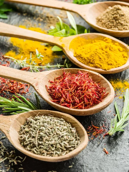 Ahşap kaşıklardaki renkli baharatların çeşitli çeşitleri.