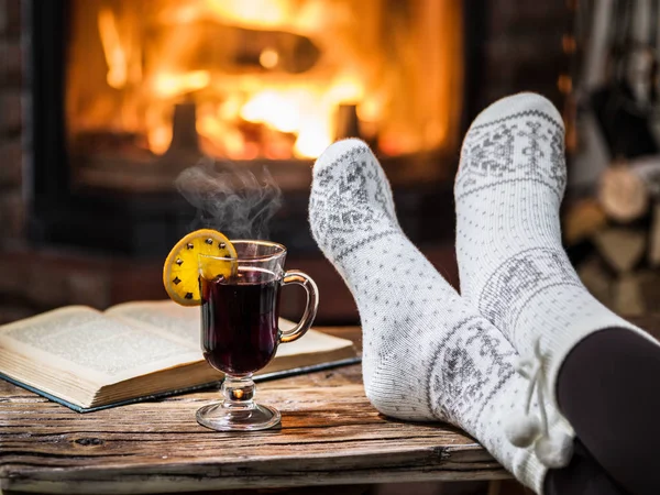 地球温暖化と暖炉のそばでリラックスできます 女性の足付近の火の前でホット ワイン カップ — ストック写真