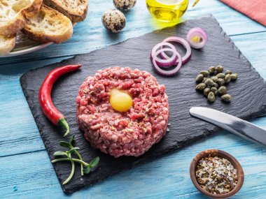 Steak tartare çiğ Bıldırcın yumurta sarısı, Kapari ve ekmek ile servis. Et yemek.