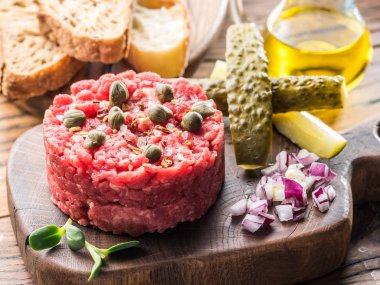 Steak tartare kapari, salatalık turşusu ve doğranmış soğan ile servis.