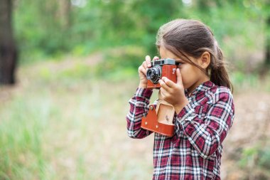 Küçük kız kamera ile doğa fotoğraflarını alıyor. Genç fotoğrafçı.