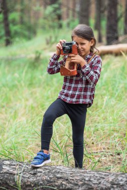 Küçük kız kamera ile doğa fotoğraflarını alıyor. Genç fotoğrafçı.