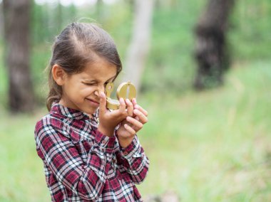 Küçük kız onun pusula bakıyor. Genç gezgin.