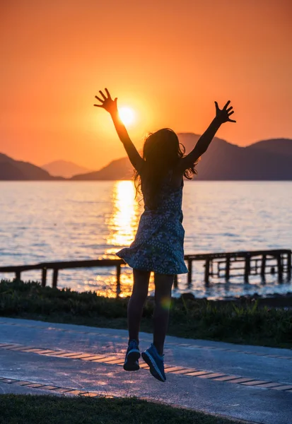 Μικρό Κορίτσι Απολαμβάνοντας Ηλιοβασίλεμα Στις Ακτές Της Θάλασσας Σιλουέτα Του — Φωτογραφία Αρχείου