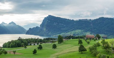 Village Horn, Mount Pilatus, Switzerland, May 13, 2018. Green spring fields and beautiful cloudy sky. clipart