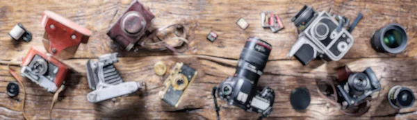 Imagen Panorámica Borrosa Diferentes Cámaras Fotográficas Sobre Fondo Madera —  Fotos de Stock