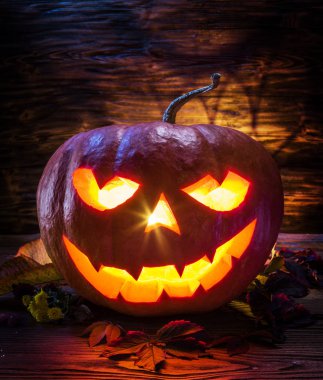 Sırıtan kabak latern veya jack-o'-lantern Cadılar Bayramı sembollerin biridir. Cadılar Bayramı özniteliği. Ahşap arka plan.