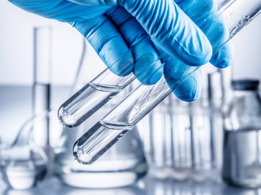 Laboratuvar kadehler analist'ın elinde plastik eldiven.