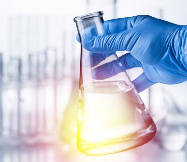 Laboratuvar kabı plastik eldiven analist'ın elinde.