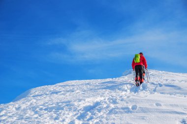 Turistler karla kaplı dağın tepesine doğru yola. Hiking kış.