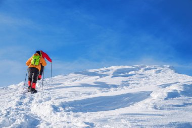 Turistler karla kaplı dağın tepesine doğru yola. Hiking kış.