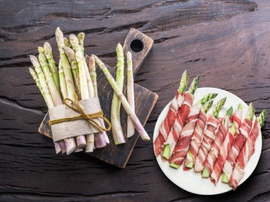 Yeşil kuşkonmaz lahanası ahşap masa jambon sarılı. Üstten görünüm.