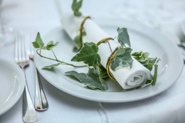 Beyaz tatil yer ayarı yeşil dal ile dekore edilmiştir. Yakın çekim.