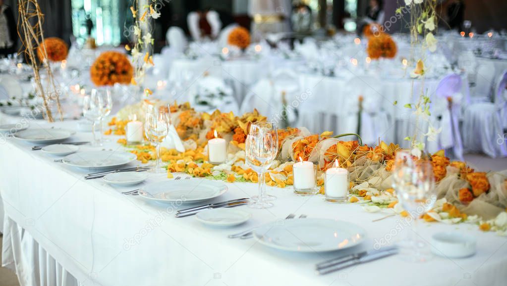 Holiday table setting decorated with flowers and candles.