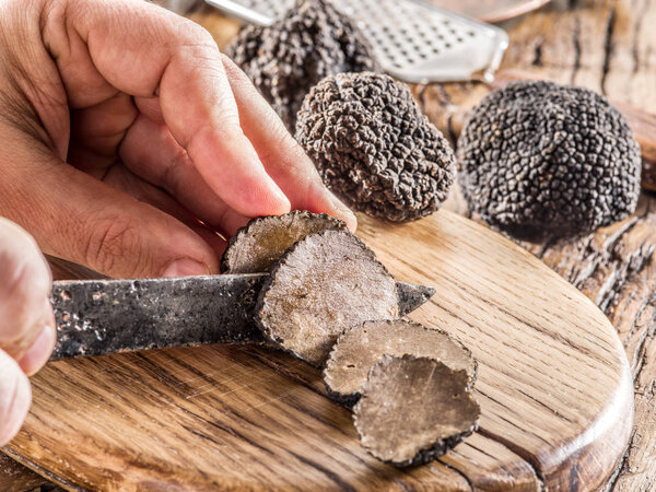 Black truffles on the old wooden table.