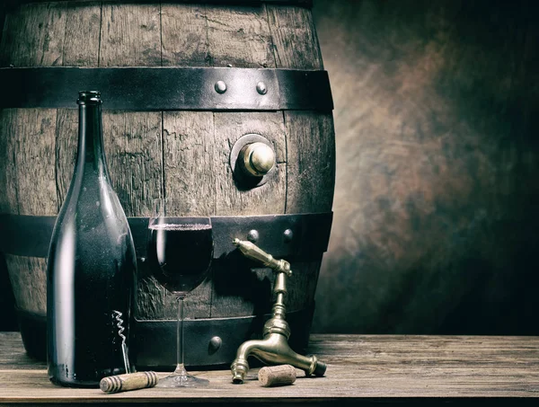 一杯红酒和酒瓶 橡木酒桶在背景 — 图库照片