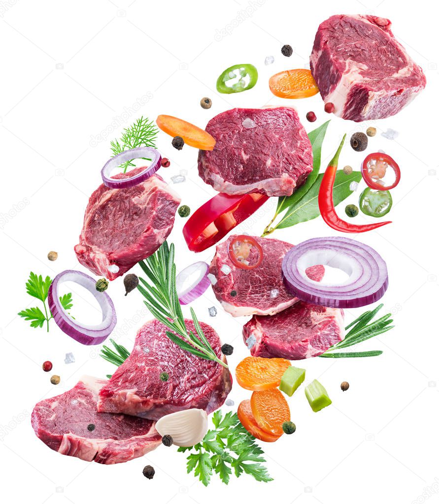 Falling down meat steaks and spices. Flying motion effect of cooking process. File clipping path.