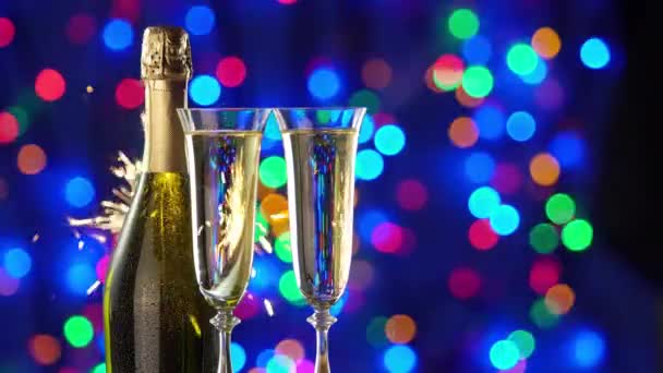 还带着一瓶香槟和眼镜过着平静的生活在明亮的灯光和圣诞假期的火花后面 — 图库视频影像