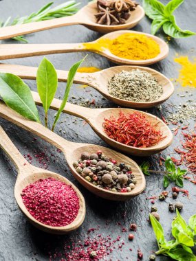 Ahşap kaşıklardaki renkli baharatların çeşitli çeşitleri.