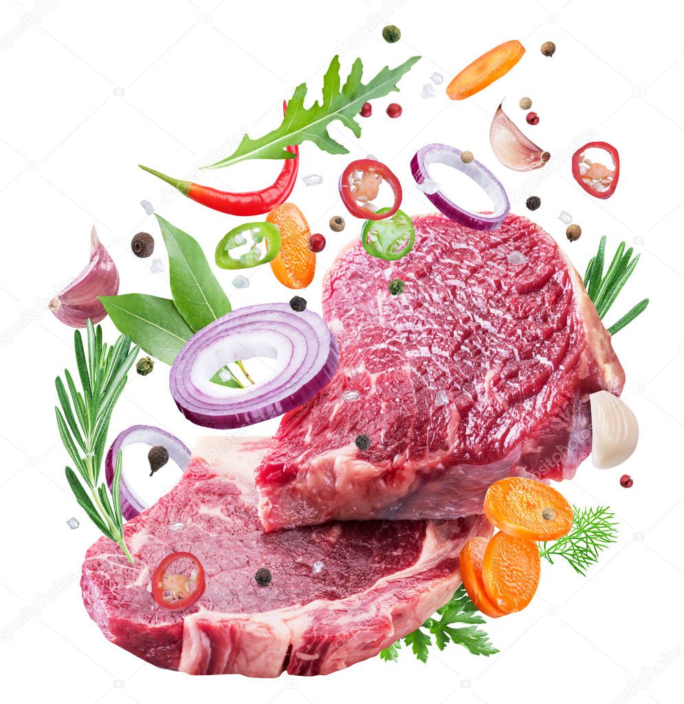 Falling down meat steaks and spices. Flying motion effect of cooking process. File clipping path.