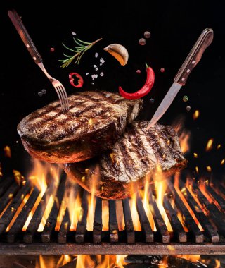 Sığır eti biftek baharatlar ile yanan mangal Barbekü ateşte sinek. Gıda uçan kavramı.