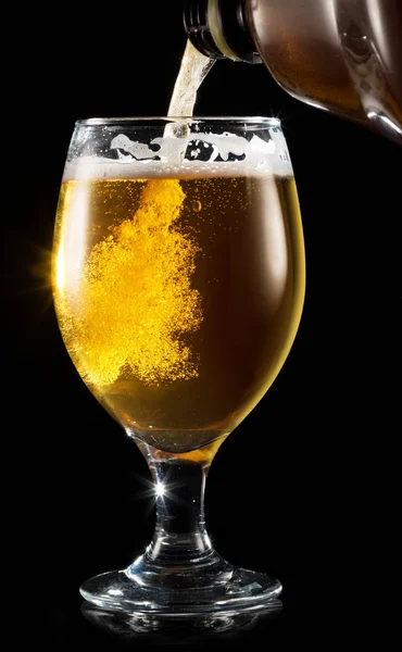 Beer pouring process. Filling a mug with a beer on white background.