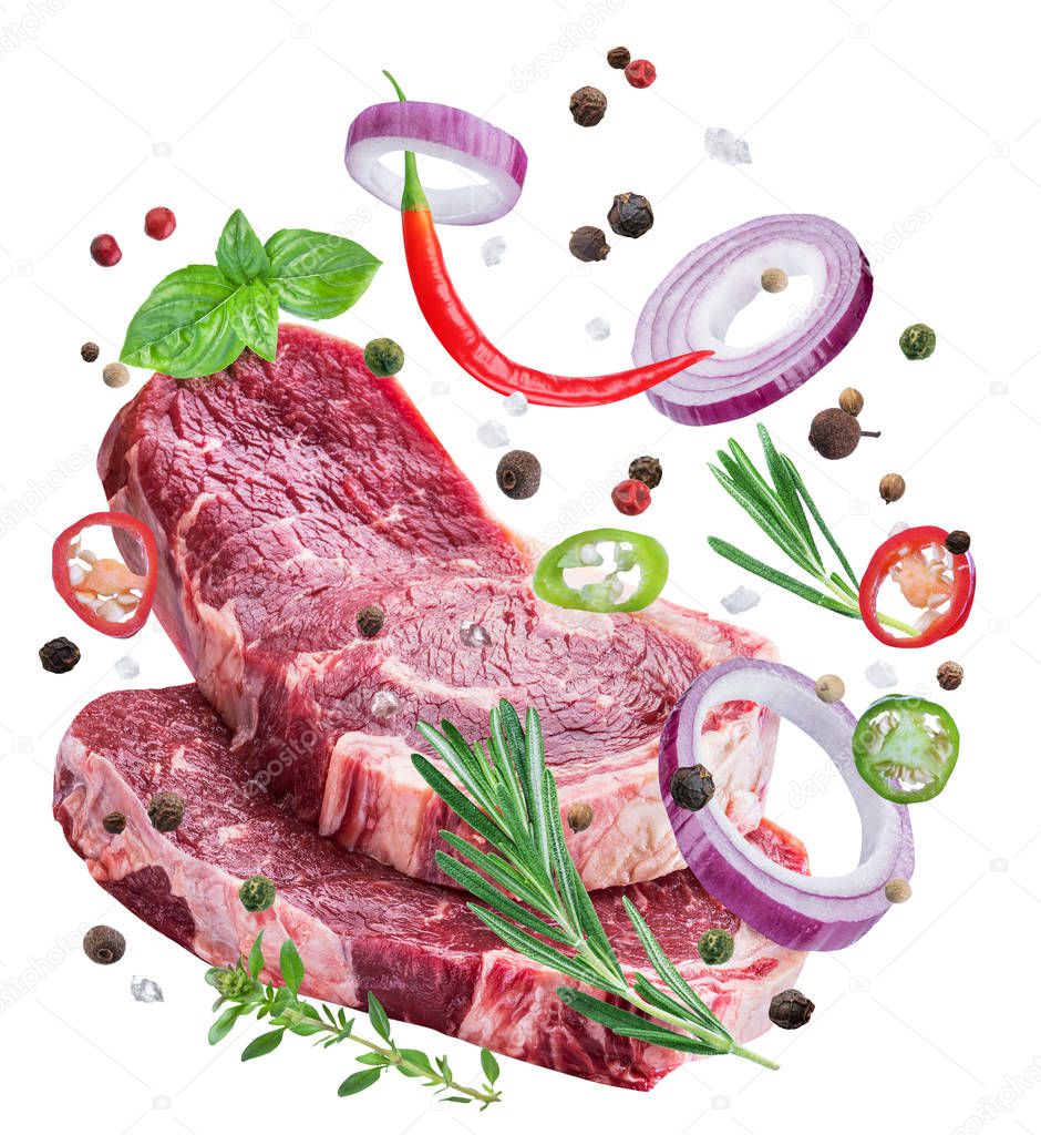 Falling down meat steaks and spices. Flying motion effect of cooking process. File clipping path.