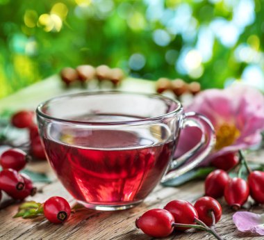 Rose-kalça ve Kuşburnu Çekirdeği Yağı ahşap masa üzerinde. Bulanık doğa arka plan.