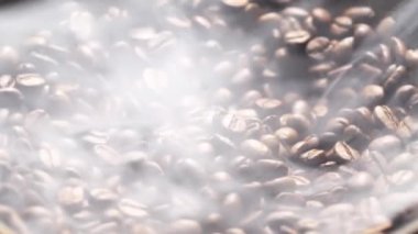 Kokulu kahve çekirdekleri kızartma tavasında kızartılır, duman kahve çekirdeklerinden gelir. Tüm kompozisyon kameranın etrafında yavaşça kayar..