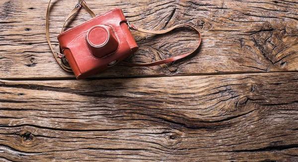 古い木製の背景に革ケースのフィルム カメラ — ストック写真