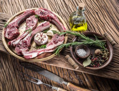 Sarımsak ve eski ahşap masa üzerinde otlar ile ham pirzola.