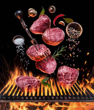 Antrikot biftek pişirme. Kavramsal resim. Baharatlar ve çatal bıçak takımı altında yanan ızgara ızgara biftek.