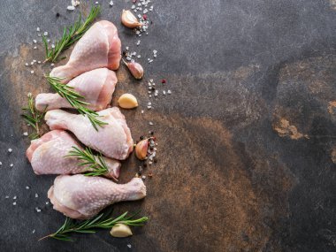 Baharat ve tuzlu tavuk bacakları kesim tahtasında pişirmeye hazır..