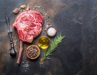 Ham antrikot biftek veya sığır eti biftek grafit kesme tahtası otlar ve baharatlar ile. Üstten görünüm.