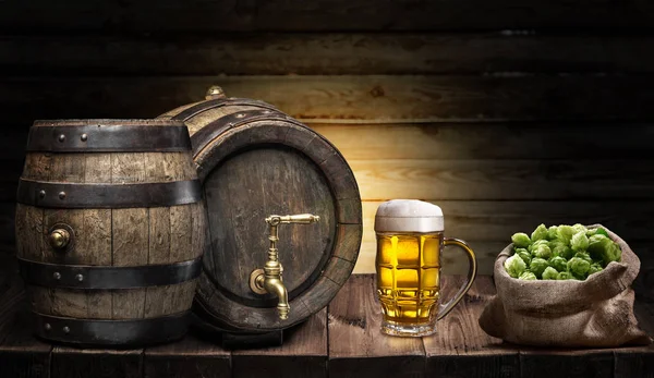 Beer mug and small keg of beer on the wooden table. Craft brewery.