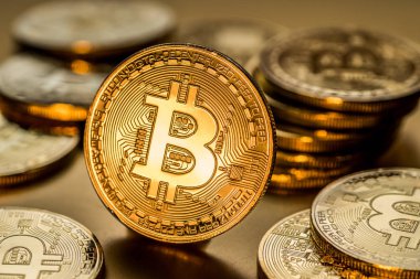 Altın arka plan üzerinde parlak fiziksel bitcoins. Blockchain teknoloji.