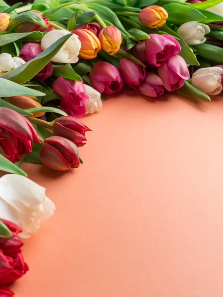 Colorful  bouquet of tulips on orange background.  Top view.