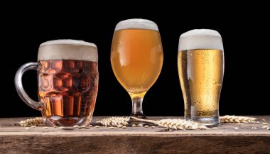 Eski ahşap masa bira gözlük. Siyah arka plan.