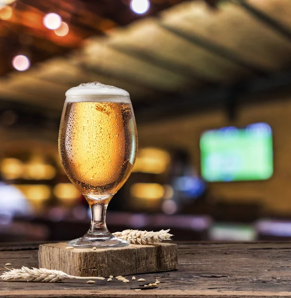 旧木桌上冰镇的清淡啤酒 模糊的酒吧背景 — 图库照片