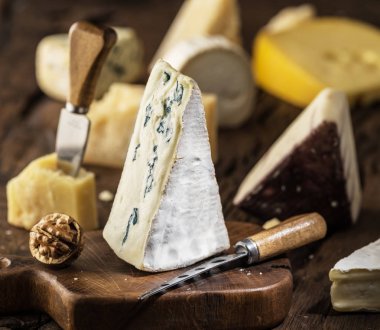 Mavi peynir ya da ahşap tahta üzerinde Cambozola peynir parçasını. Arka plan, farklı peynir.