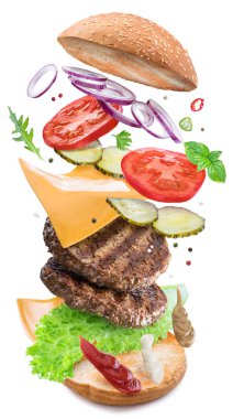 Hamburger malzemeler tek mükemmel bir yemek oluşturmak için bir düşüyor. Renkli kavramsal resmi yemek hamburger. Kırpma yolu.