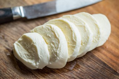 Su bufalosu dilim ahşap arka plan üzerinde mozzarella peynir. Yakın çekim.